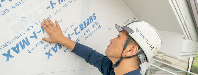 建物の防水シートを確認している