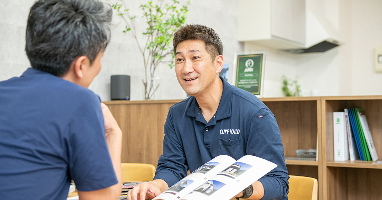 顧客にパンフレットを見せながら相談